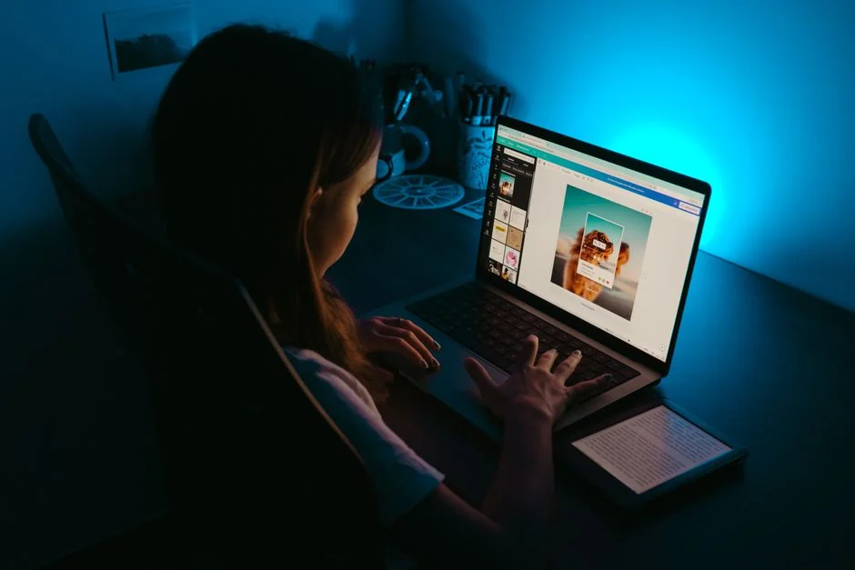 Close-up shot of an orange credit card held above a laptop, emphasizing digital payment.
